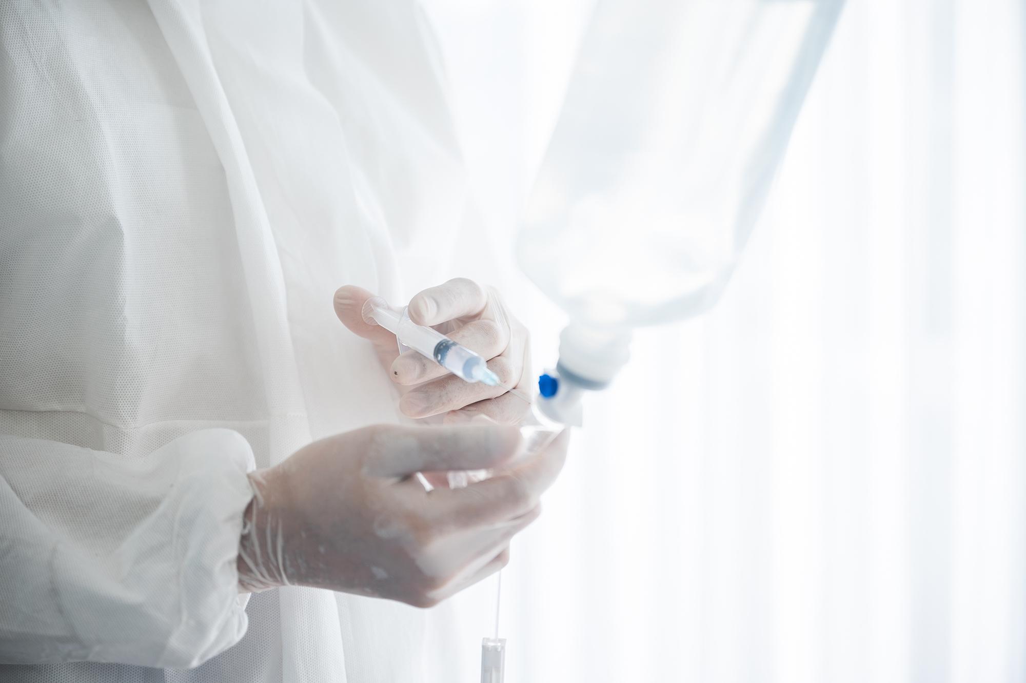 A doctor injecting a needle into a bag