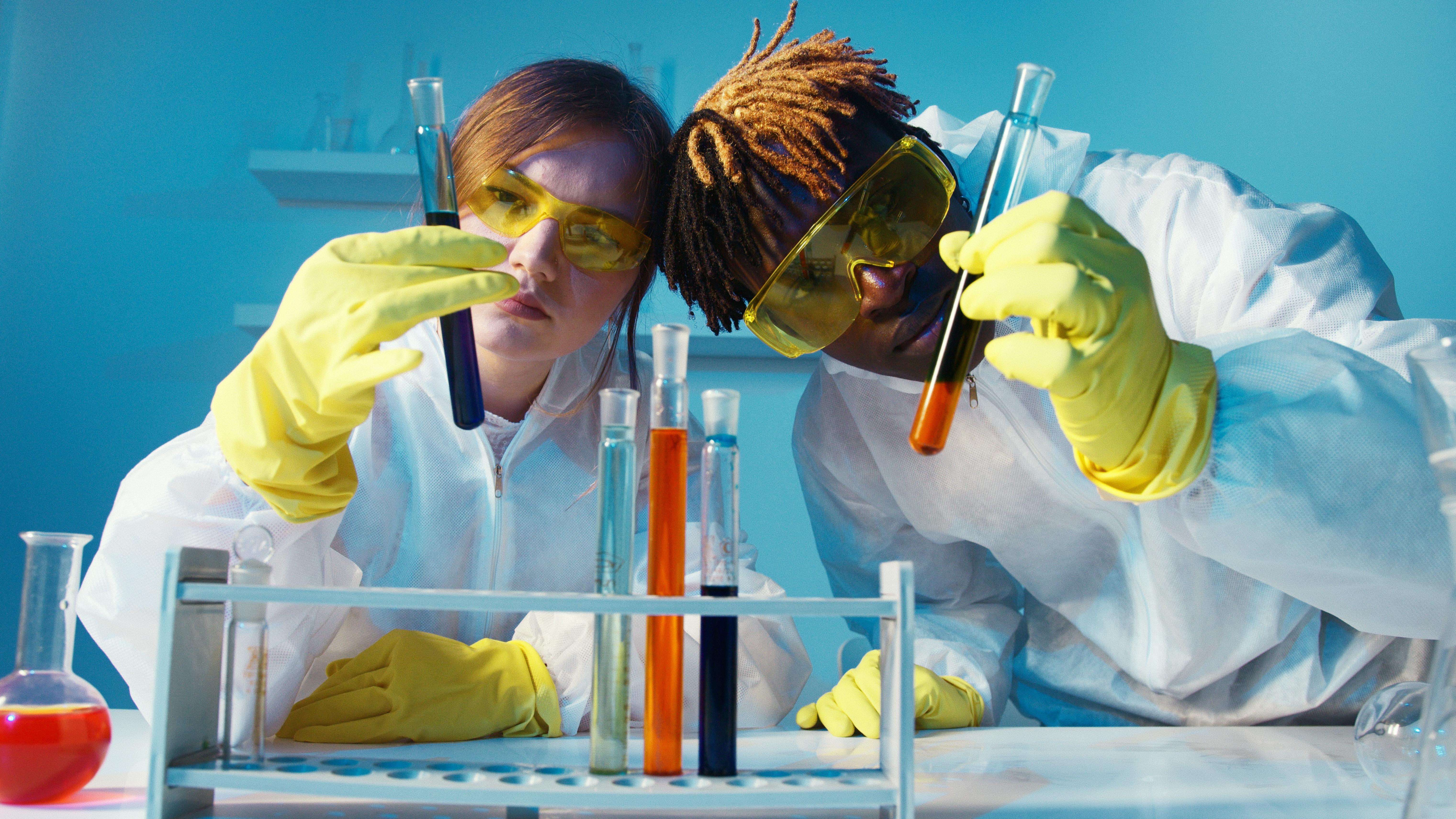 Two students examining tubes with chemicals inside